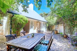 a wooden table and chairs in a yard at Sunbird Cottage - Wilderness in Wilderness