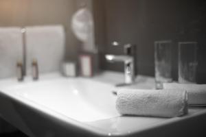 a bathroom counter with a sink with a towel on it at Best Western Plus Lakeside Hotel in Székesfehérvár