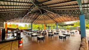 a restaurant with tables and chairs under a large umbrella at Hotel Dolce Dulce in Olímpia