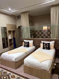 a bedroom with two beds with portraits of dogs on them at Riad Ras Lafaa in Safi
