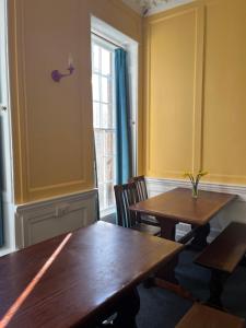 a dining room with two tables and a window at Bath Backpackers in Bath