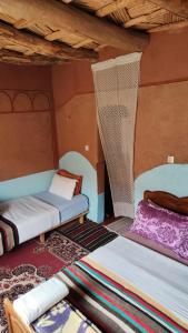 a room with two beds in a room at maison isabel in Boumalne Dades