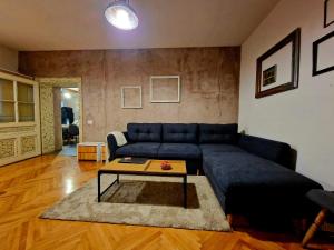 un soggiorno con divano blu e tavolino da caffè di Nomad Apartment Braşov a Braşov