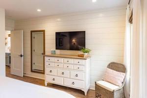 a bedroom with a dresser with a tv on the wall at Downtown Luxury Farmhouse Apartment #1 in West Dundee