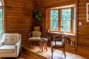 uma sala de estar com uma secretária e cadeiras num camarote em Cozy 2 Bedroom Cabin Nestled in Wooded Hideaway em Monterey