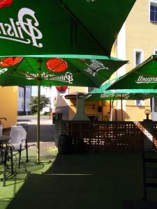 a group of green umbrellas on a patio at Penzion U Antonickova Pramene in Mariánské Lázně