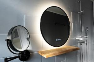 a bathroom with a mirror and a wooden shelf at City - Apartment Weststadt in Karlsruhe