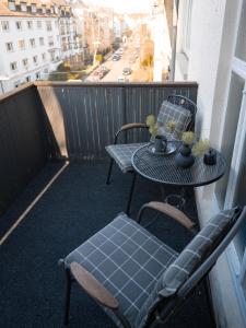a balcony with two tables and chairs on a balcony at City - Apartment Weststadt in Karlsruhe