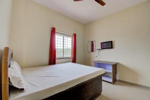 - une chambre avec un lit et une fenêtre avec des rideaux rouges dans l'établissement SPOT ON San Tower Hotel, à Kilimanūr