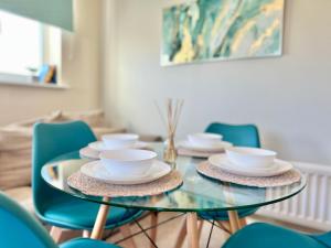 a glass table with bowls and saucers on it at Perfect for long stays - Families & Contractors in Hatfield +14 photos