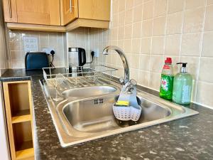 a kitchen sink with a dish drying rack and a detergent at Bright, stylish flat in Hatfield sleeps 4 in Hatfield
