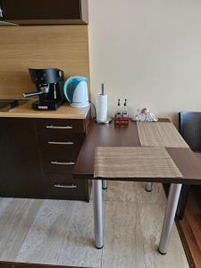 uma cozinha com uma mesa de madeira e comodidades para preparar café em City Sandanski em Sandanski