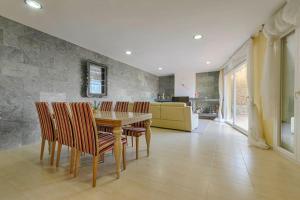 una sala da pranzo con tavolo e sedie in legno di Excepcional villa con vistas panorámicas a la Bahía de Rosas IMMO365 a Palau-Saverdera