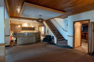 - un salon avec un escalier dans une maison dans l'établissement Auberge le Parasol, à Saguenay