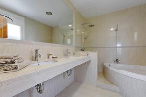 un bagno con due lavandini, una vasca e un grande specchio di Excepcional villa con vistas panorámicas a la Bahía de Rosas IMMO365 a Palau-Saverdera Altre 15 foto
