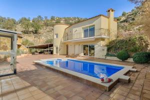 una casa con piscina di fronte a una casa di Excepcional villa con vistas panorámicas a la Bahía de Rosas IMMO365 a Palau-Saverdera