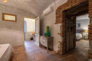 une chambre avec un lit et un mur de briques dans l'établissement Dimoras Dimore nel cuore di Olbia, à Olbia