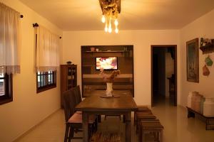 uma sala de jantar com uma mesa e uma televisão em Morada Das Cerejeiras - Espaçosa e Ideal para Pets em Rio Forcação
