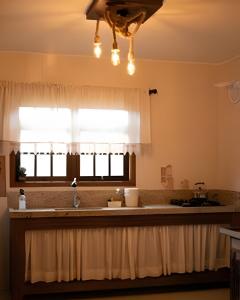 uma cozinha com um lavatório e uma janela em Morada Das Cerejeiras - Espaçosa e Ideal para Pets em Rio Forcação