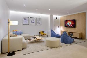 a living room with a couch and blue chairs at Apartamentos Luna Suites Granada in Granada