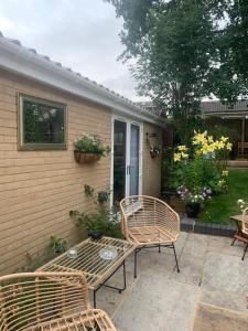 a patio with two wicker chairs and a table at The chalet in Chandlers Ford