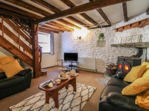 a living room with couches and a wood stove at Y Cartws in Llanybyther