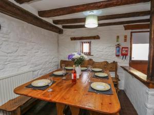 a wooden table with plates and wine glasses on it at Y Cartws in Llanybyther