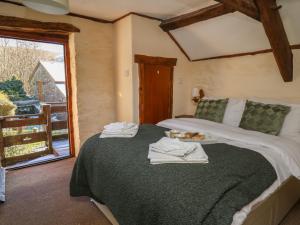 een slaapkamer met een bed met handdoeken erop bij Y Cartws in Llanybyther