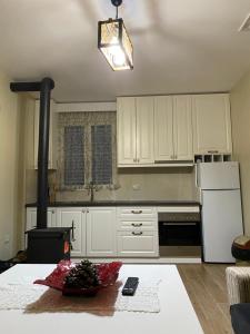 a kitchen with white cabinets and a table with a bowl of fruit at Guest House Laci in Tirana