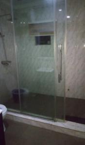 a glass shower in a bathroom with a toilet at DND Apartments in Benin City