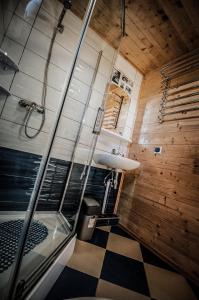 a bathroom with a shower and a checkered floor at Baltic Summer - ośrodek dla rodzin z dziećmi in Rewa
