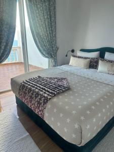 a large bed in a bedroom with a large window at Riad Ras Lafaa in Safi