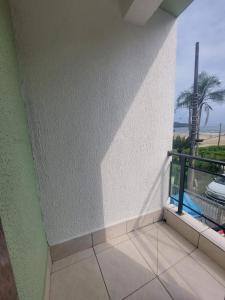 a room with a balcony with a view of the ocean at Pousada Nascimentos in Bertioga