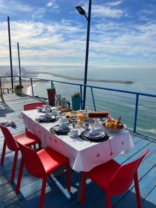 a table with food on top of a balcony with the ocean at Riad Ras Lafaa in Safi