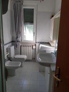 uma casa de banho com dois WC e dois lavatórios e uma janela em La Palma em Ameglia