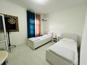 1 dormitorio con 2 camas, lavabo y espejo en Hotel Uncle Kolya Boutique, en Bukhara
