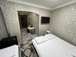 a hotel room with two beds and a mirror at Hotel Uncle Kolya Boutique in Bukhara