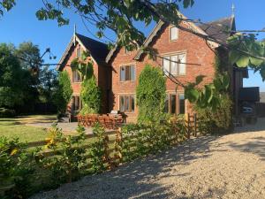 a large brick house with benches in front of it at 8 Bed in Abbots Bromley 79321 in Abbots Bromley