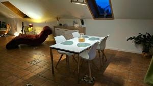 a dining room with a white table and white chairs at Surforama Studio Apartment mit Meerblick und Garten in Fehmarn +7 photos