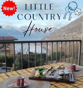 einen Tisch auf einem Balkon mit Blick auf ein kleines Landhaus in der Unterkunft Little Country House in Bellano