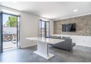 a dining room with a white table and a tv on a wall at Casa Lanço with Spectacular View in Funchal