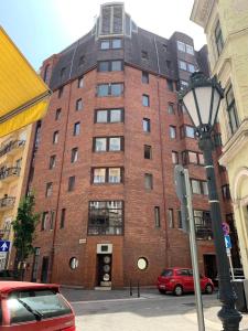 een hoog bakstenen gebouw met een straatlicht ervoor bij Flat White Apartment in Boedapest