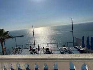 a balcony with tables and chairs and the ocean at Riad Ras Lafaa in Safi