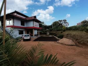 a house with a car parked in front of it at Jishi Homestay in Madikeri