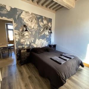 Mesnil Montrivaut في Viévigne: غرفة نوم بسرير مع جدار ازهار