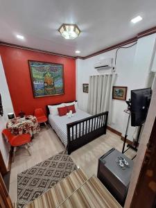 Habitación pequeña con cama y TV. en Country Bug Inn, en Tagaytay