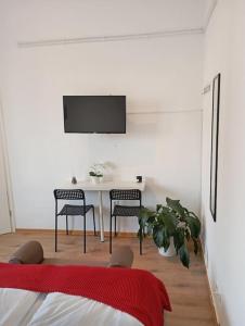 Cette chambre blanche dispose d'une table, de chaises et d'une télévision. dans l'établissement Apartment Koblenz nähe Uni und BWZK, à Coblence