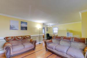 a living room with two couches and a table at Lorton Vacation Rental Home with Backyard and Deck! in Lorton