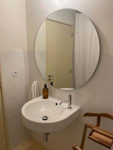 uma casa de banho com um lavatório branco e um espelho. em Porto Siza Apartment em Porto