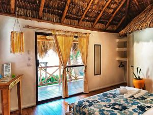 a bedroom with a bed and a large window at Hotel Cabañas Puesta del Sol in Las Peñitas